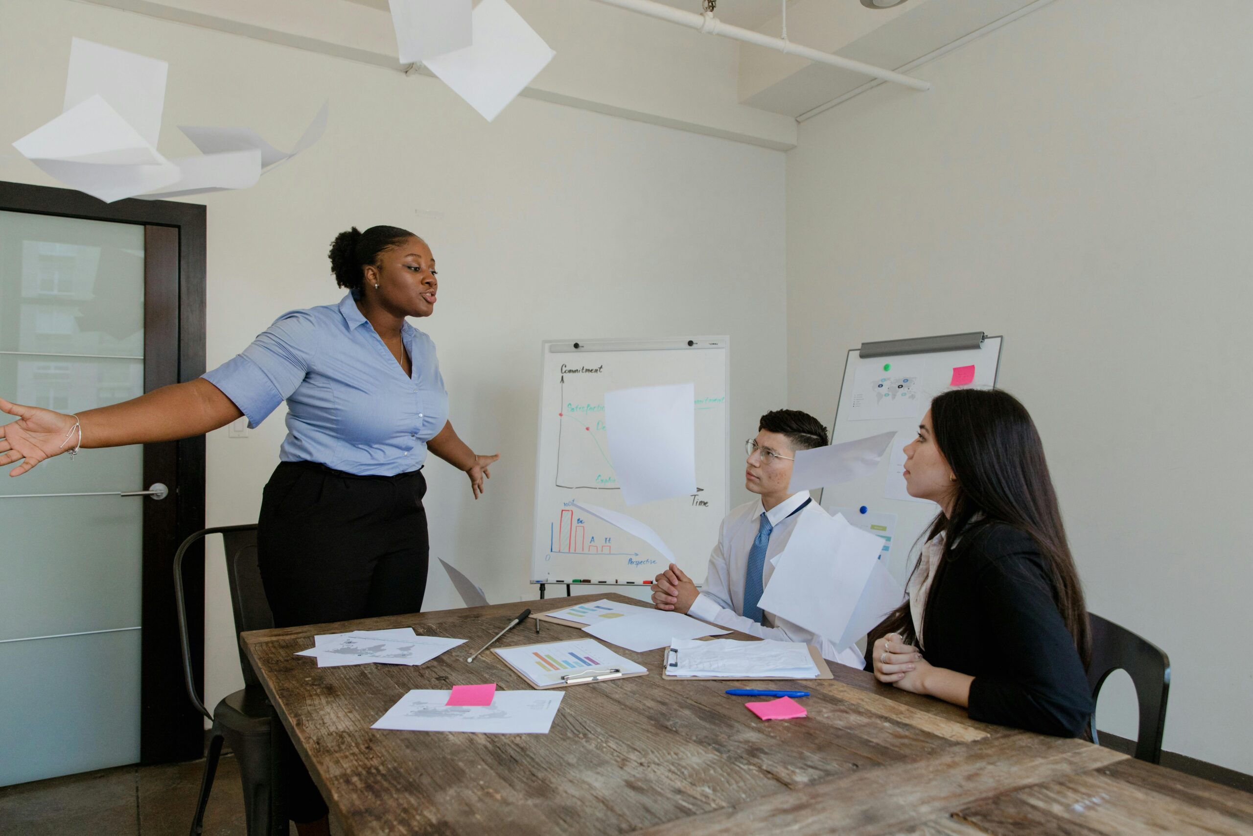 Senior leaders in a tense boardroom meeting, symbolizing workplace conflict.