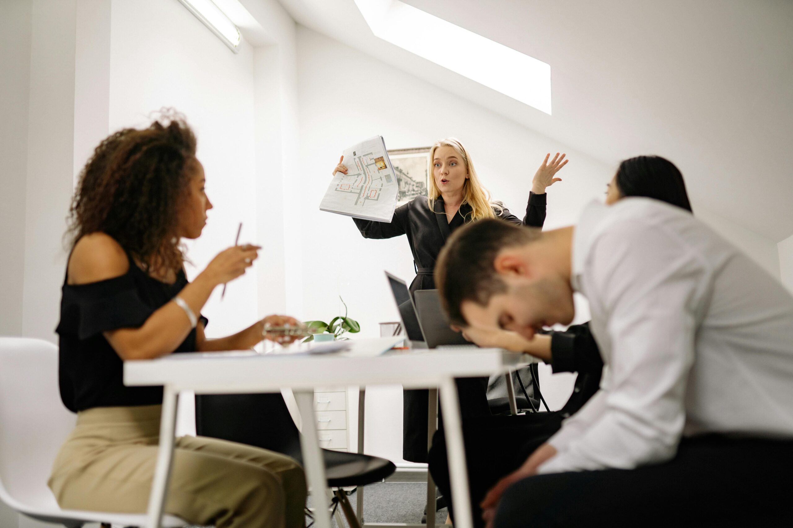 A diverse group in a workplace setting engaging in conflict resolution guided by a trauma-informed facilitator.